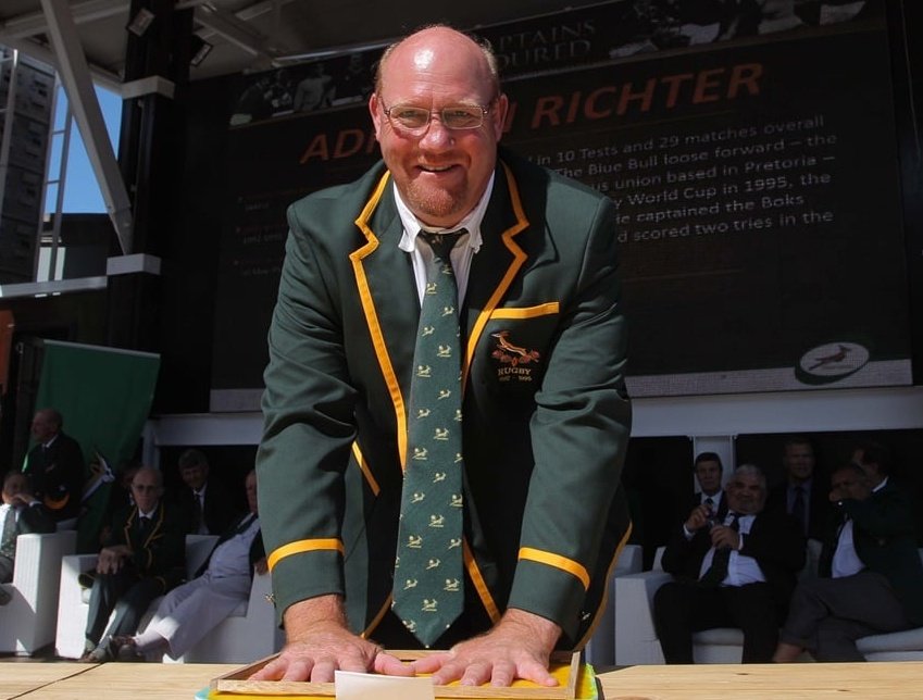 Adriaan Richter in rugby blazer at public event.