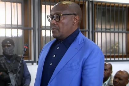 Man in blue suit standing in courtroom.