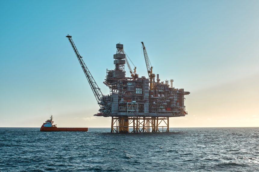 Offshore oil rig platform with supply vessel nearby.