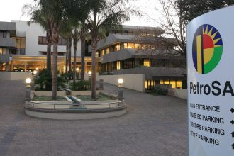 PetroSA headquarters entrance with signage and palm trees.
