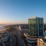 Aerial view of cityscape and beachfront at sunset.