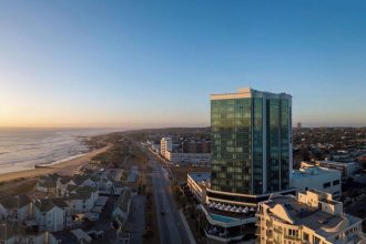 Aerial view of cityscape and beachfront at sunset.