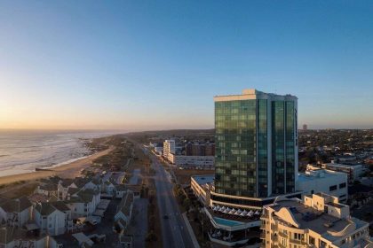 Aerial view of cityscape and beachfront at sunset.