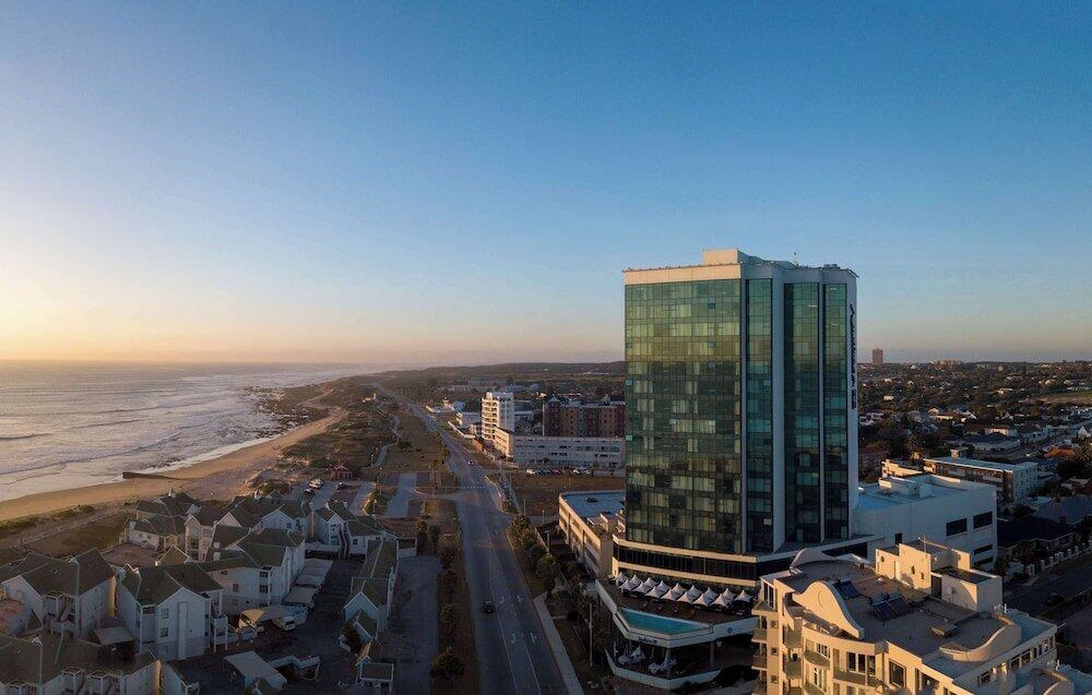 Aerial view of cityscape and beachfront at sunset.