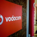Vodacom logo on brick wall in office lobby.
