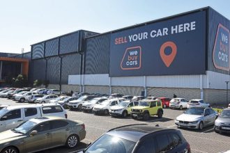 Cars parked outside vehicle sales building - WeBuyCars