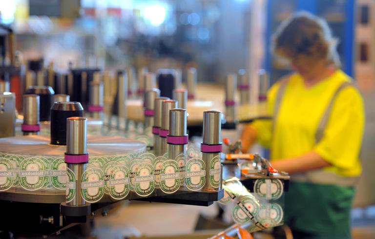 A worker checks labelling of bottles of beer at the production line of Dutch brewer Heineken factory on June 7, 2011 in Schiltigheim, eastern France, during an official visit announcing the group's goals for sustainable development, by reducing the amount of glass in some beer bottles' production, and lowering by 20 percent the energy needed at its Alsacian factory. [Photo by PATRICK HERTZOG/AFP via Getty Images]