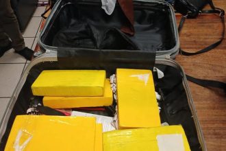 Suitcase filled with yellow wrapped packages