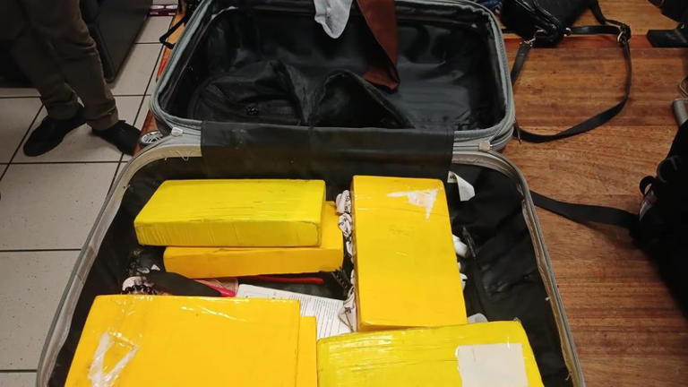 Suitcase filled with yellow wrapped packages