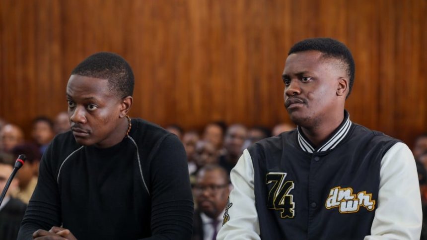 Two men seated in courtroom during hearing