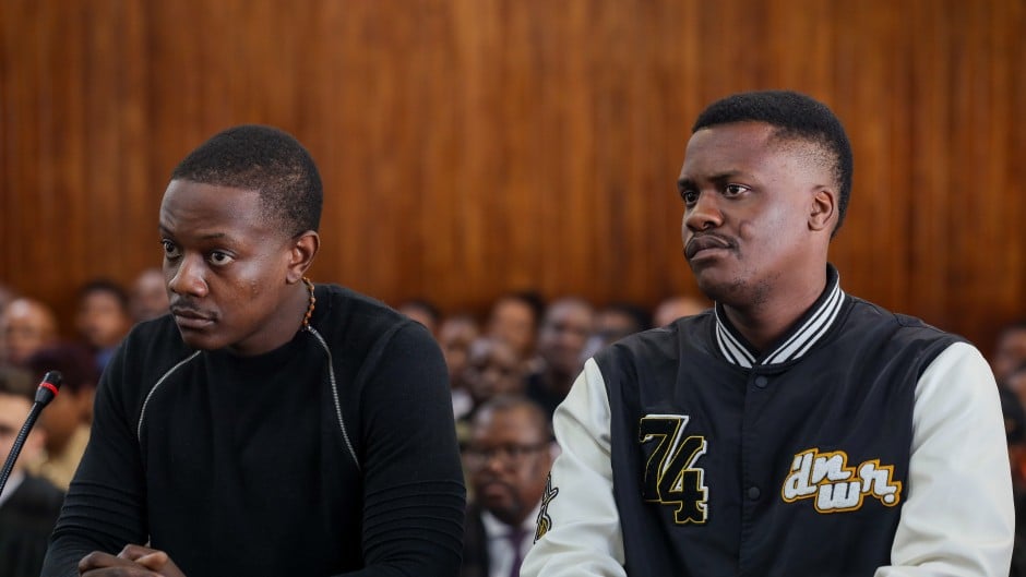 Two men seated in courtroom during hearing
