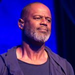 Male performer on stage under blue lighting