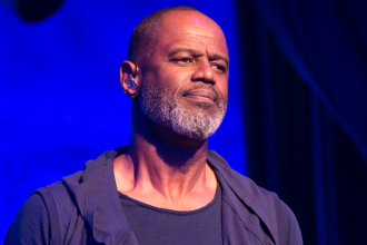 Male performer on stage under blue lighting