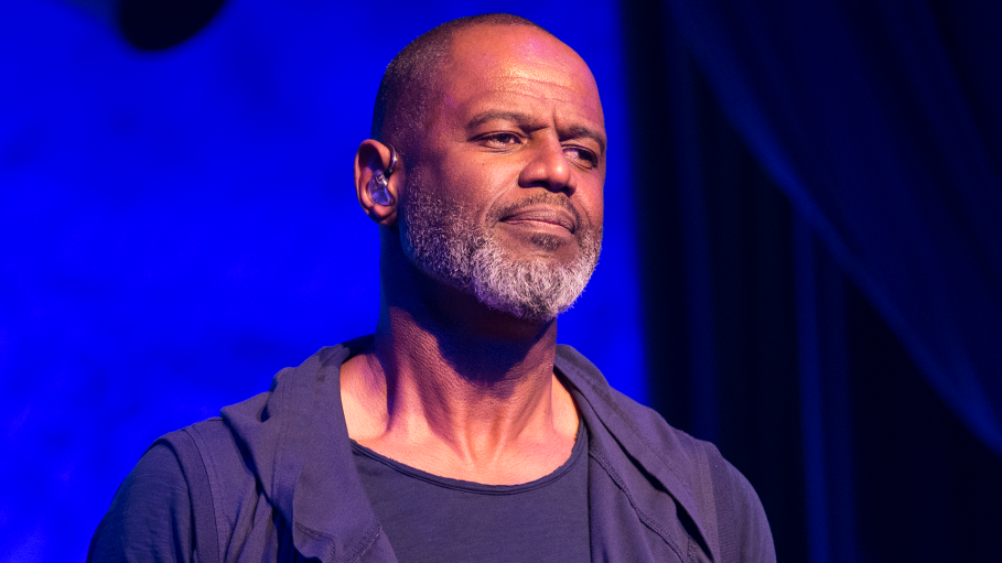 Male performer on stage under blue lighting