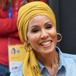 Smiling woman wearing yellow headscarf and hoop earrings