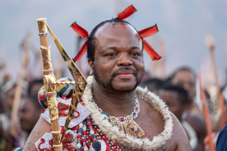 Man in traditional Zulu attire holding spear