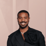 Smiling man in black suit with floral detail