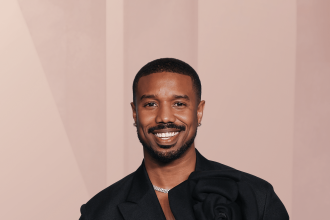 Smiling man in black suit with floral detail