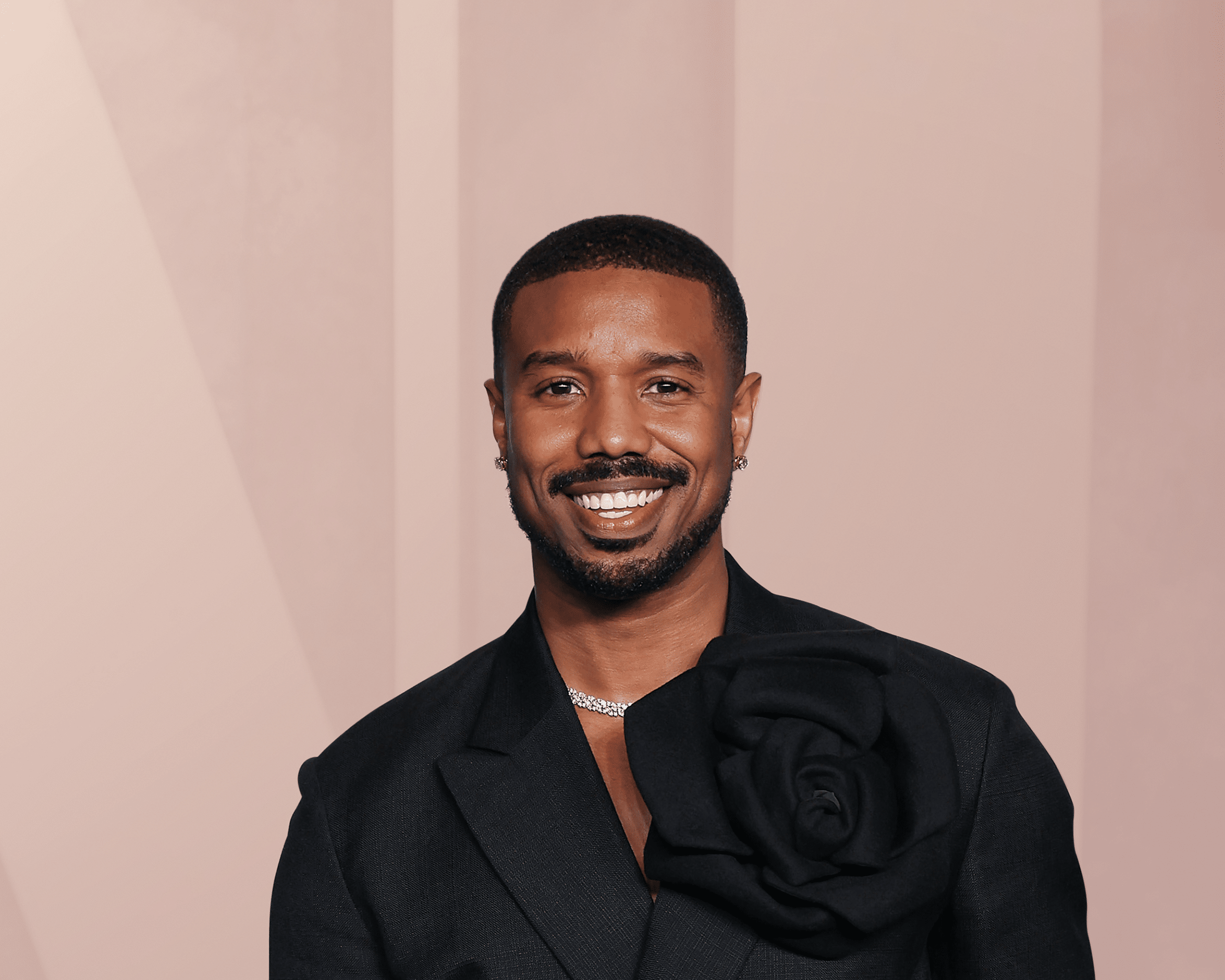 Smiling man in black suit with floral detail