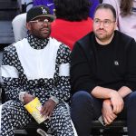 Two men seated courtside at basketball game