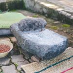 Traditional stone grinder with basket of grains