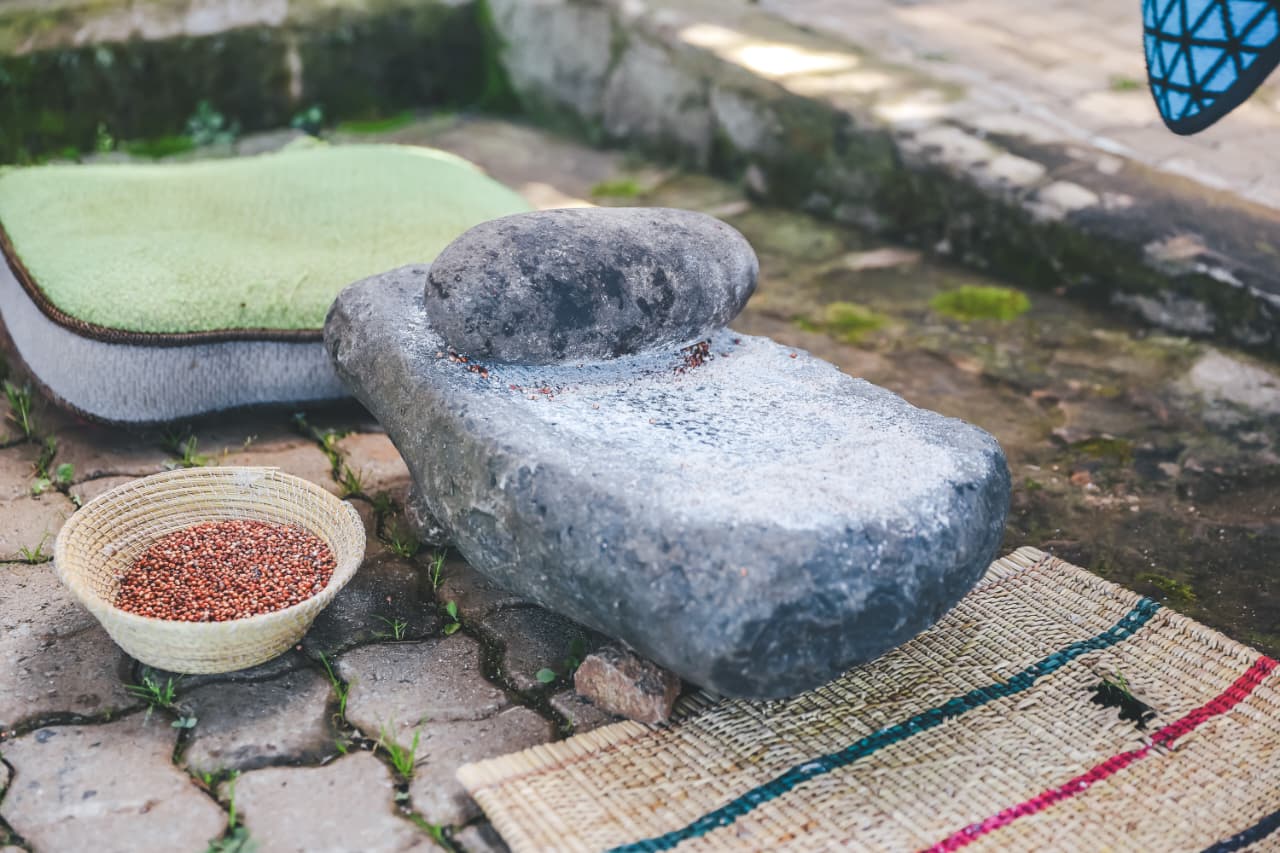 Traditional stone grinder with basket of grains