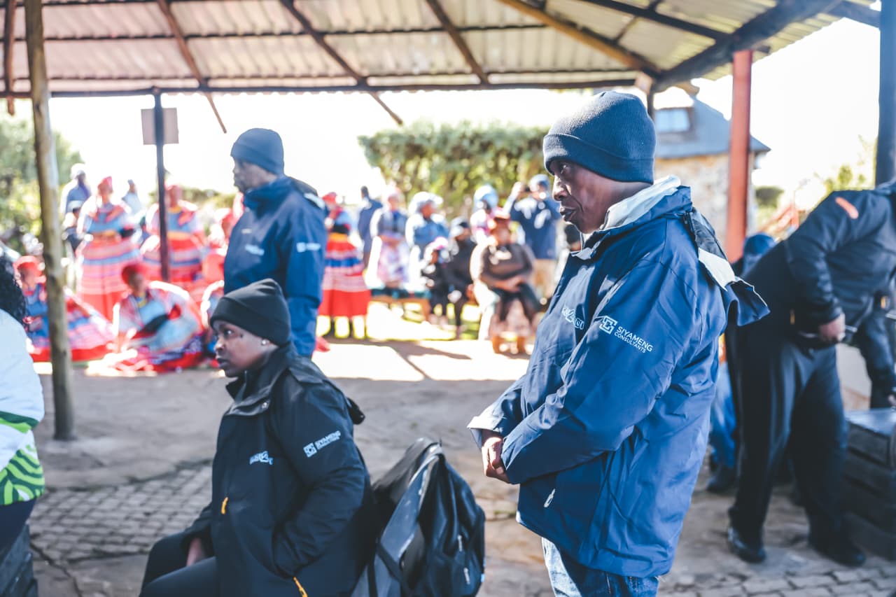 Community gathering with staff and traditionally dressed women