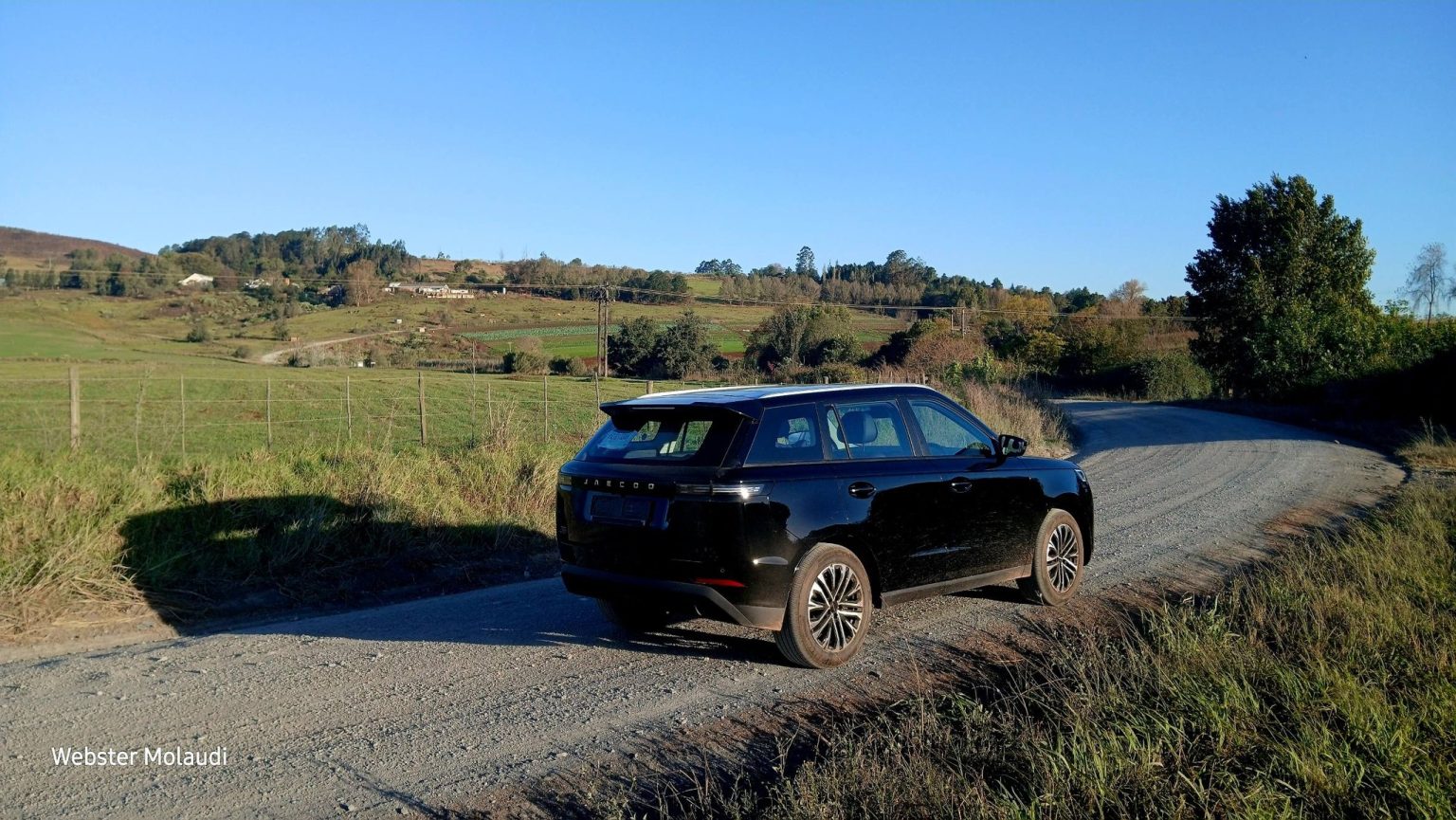 Black SUV parked on rural gravel road