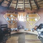 Traditional thatched hut interior with pottery displays