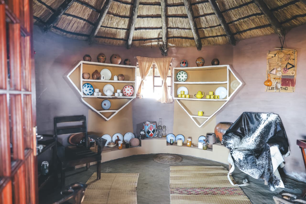 Traditional thatched hut interior with pottery displays