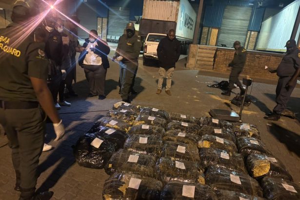 Officials inspect seized packages at warehouse at night