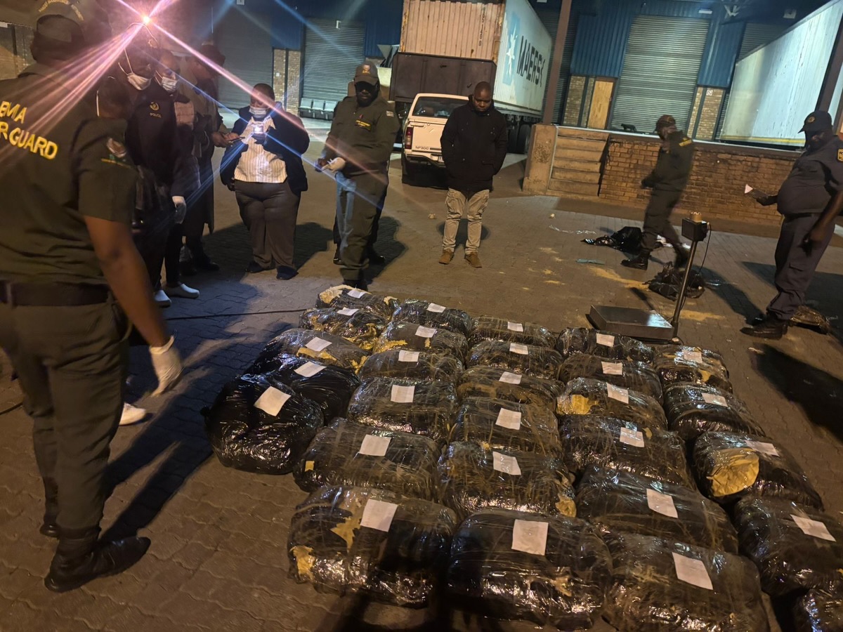 Officials inspect seized packages at warehouse at night