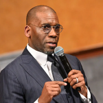 Man in suit speaking into microphone