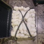Open suitcase packed with white wrapped bundles