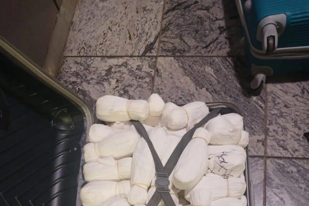 Open suitcase packed with white wrapped bundles