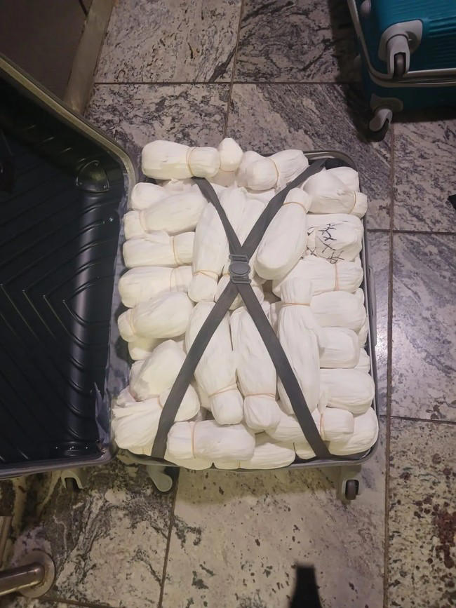 Open suitcase packed with white wrapped bundles