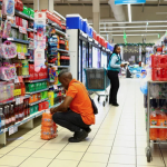 Man choosing cooldrinks in supermarket aisle