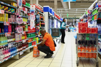 Man choosing cooldrinks in supermarket aisle