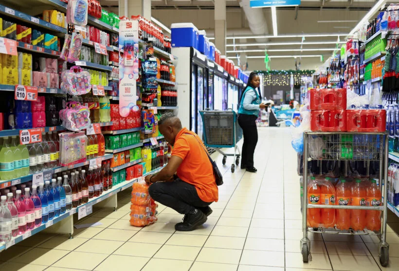 Man choosing cooldrinks in supermarket aisle
