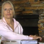Older woman sitting at desk with papers
