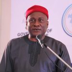 Man in red cap speaking at podium