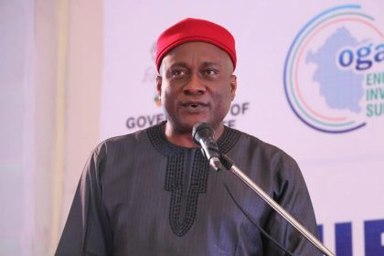 Man in red cap speaking at podium
