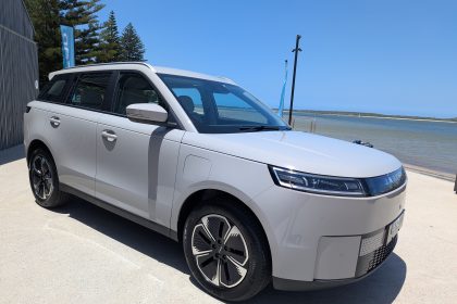 White electric MPV parked by seaside promenade