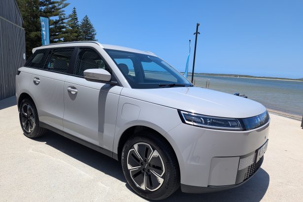 White electric MPV parked by seaside promenade