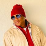 Person wearing red beanie and sunglasses outdoors