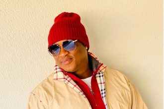 Person wearing red beanie and sunglasses outdoors