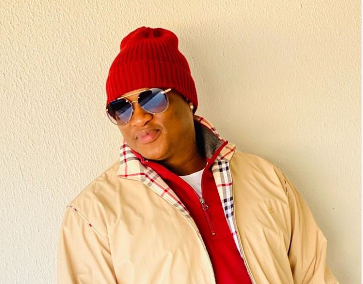 Person wearing red beanie and sunglasses outdoors