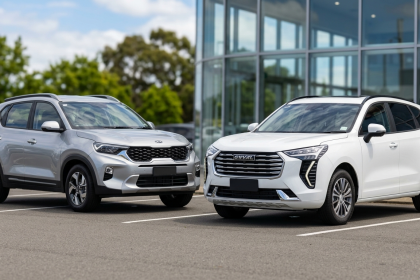 Two modern SUVs parked outside glass building
