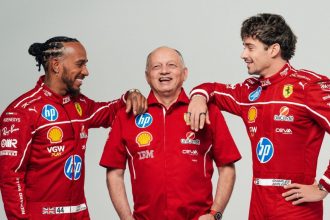 Three Ferrari racing team members in red uniforms