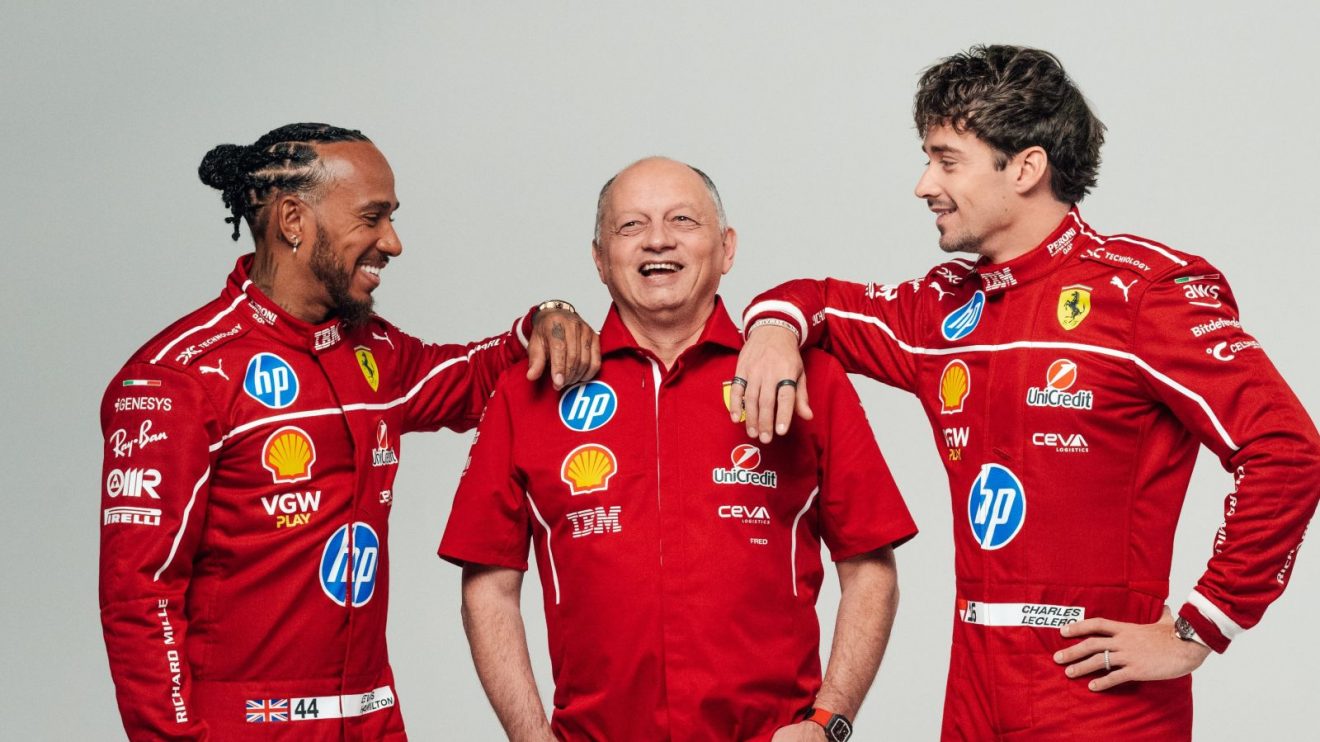 Three Ferrari racing team members in red uniforms